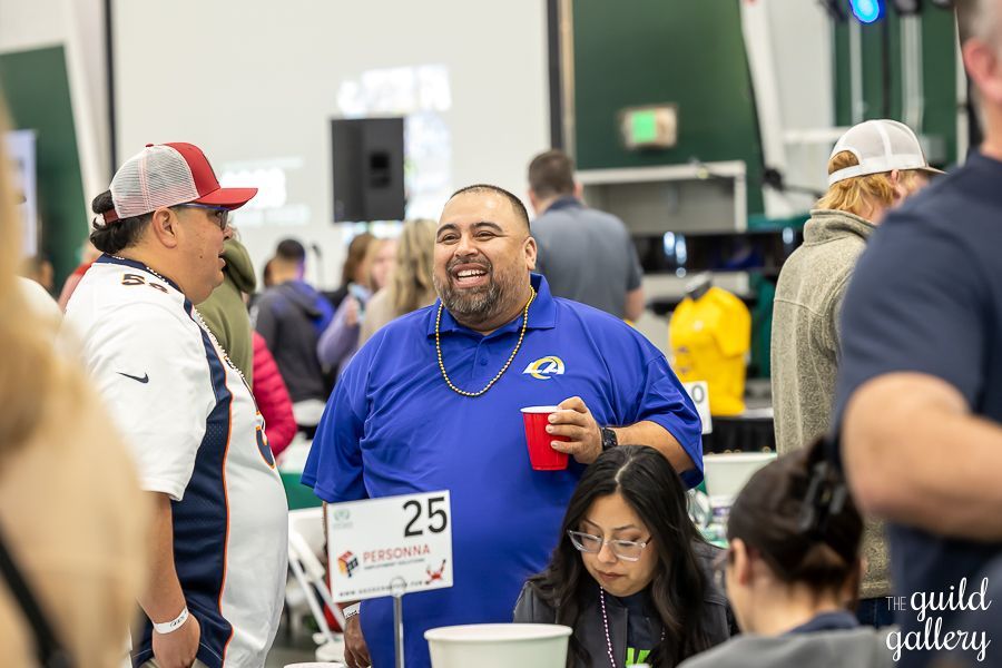 A man in a blue shirt is standing in a crowd of people.