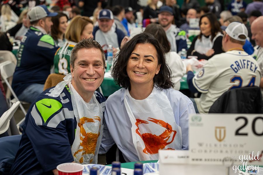 A man and a woman are posing for a picture while sitting at a table.