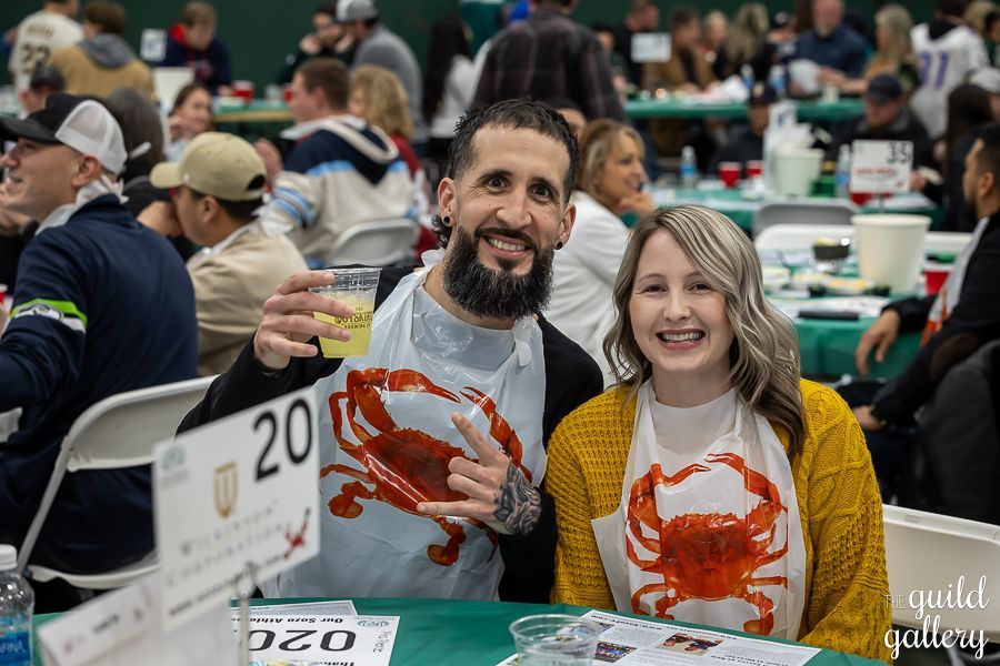 A man and a woman are posing for a picture at a table at a restaurant.