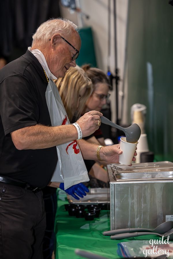 A man is pouring something into a cup with a ladle.