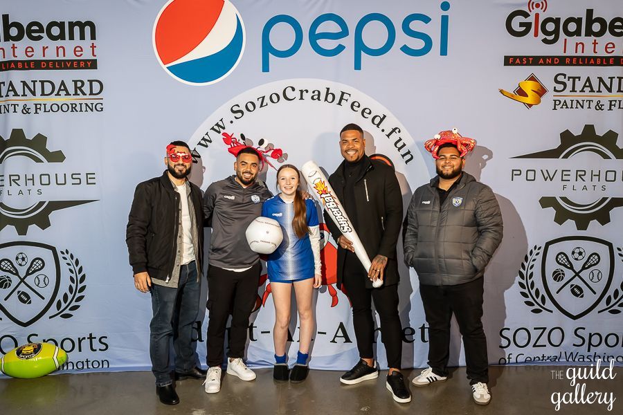 A group of people standing in front of a pepsi sign