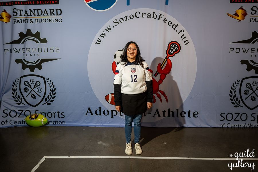 A woman wearing a white jersey with the number 12 on it