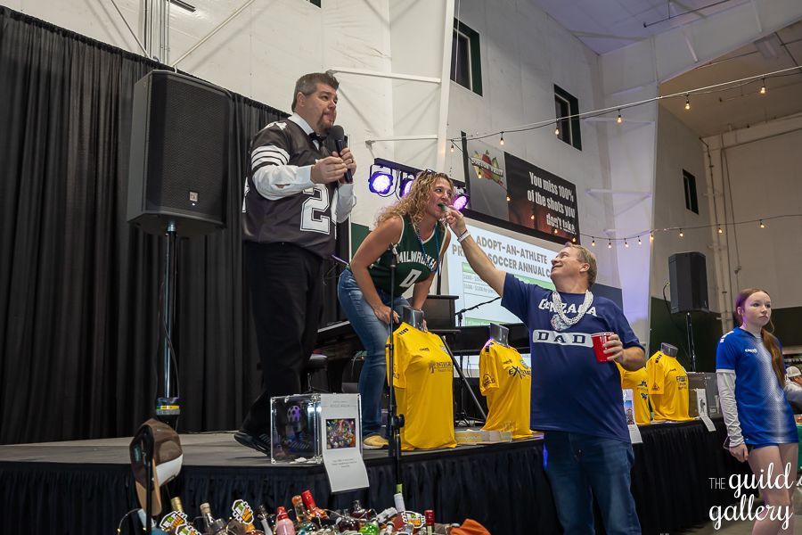 A group of people are standing on a stage in a room.