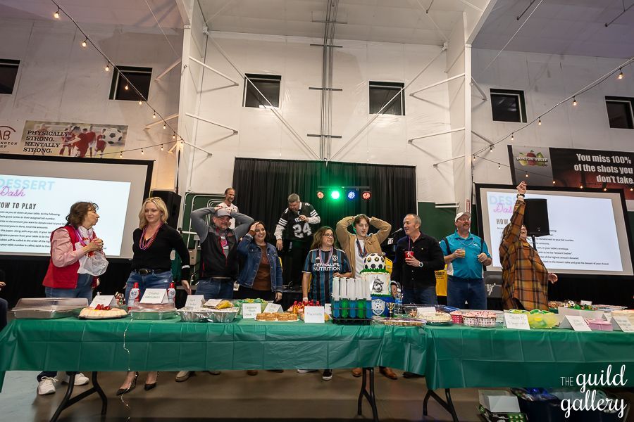 A group of people are standing around a table in a room.