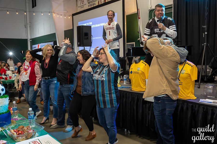 A group of people are standing in front of a large screen.