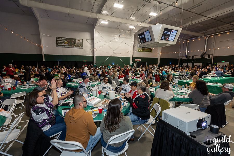 A large group of people are sitting at tables in a large room.