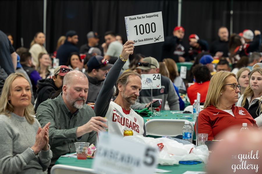 A man is holding a sign that says 1000 in front of a crowd of people.