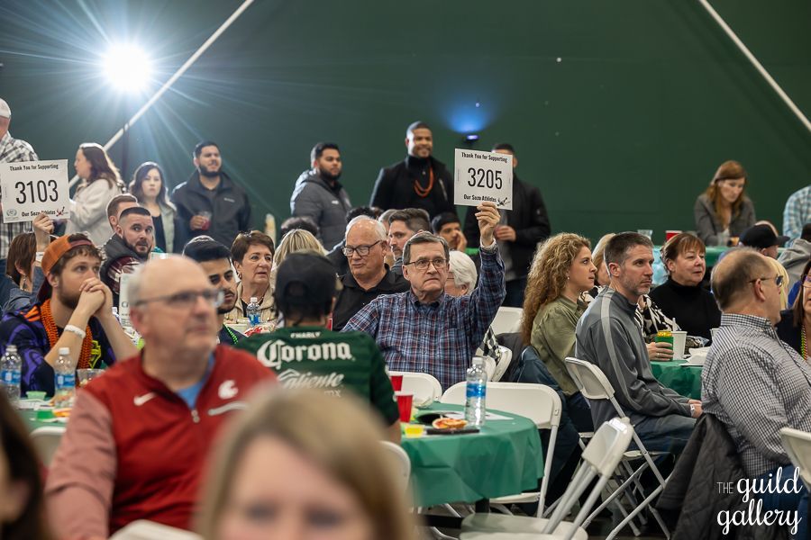 A large group of people are sitting at tables in a room.