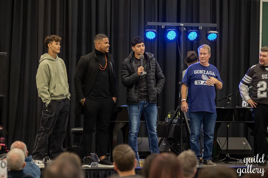 A group of men are standing on a stage in front of a crowd.