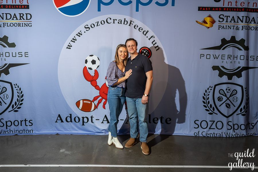 A man and woman standing in front of a pepsi banner