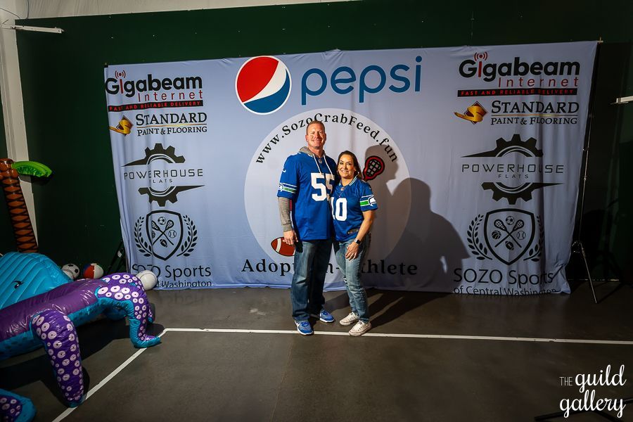 A man and woman standing in front of a pepsi banner
