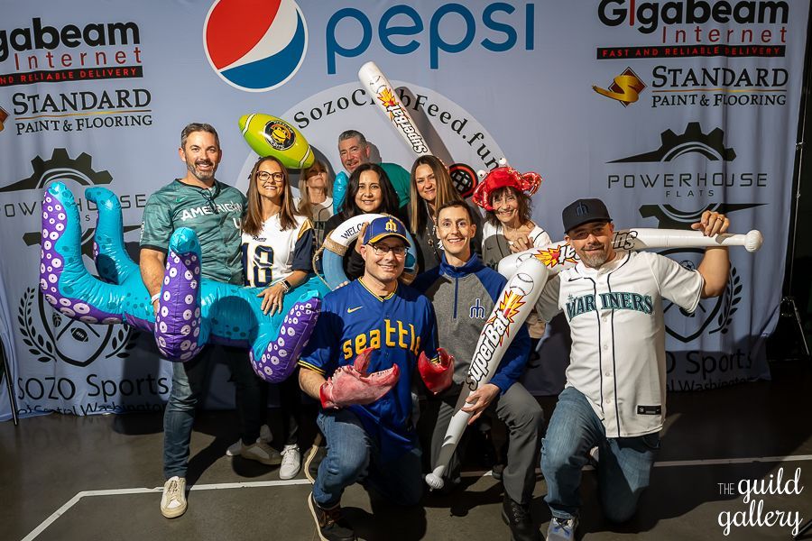 A group of people are posing for a picture in front of a pepsi banner.
