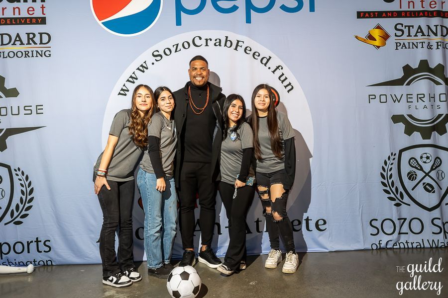 A group of people standing in front of a pepsi sign