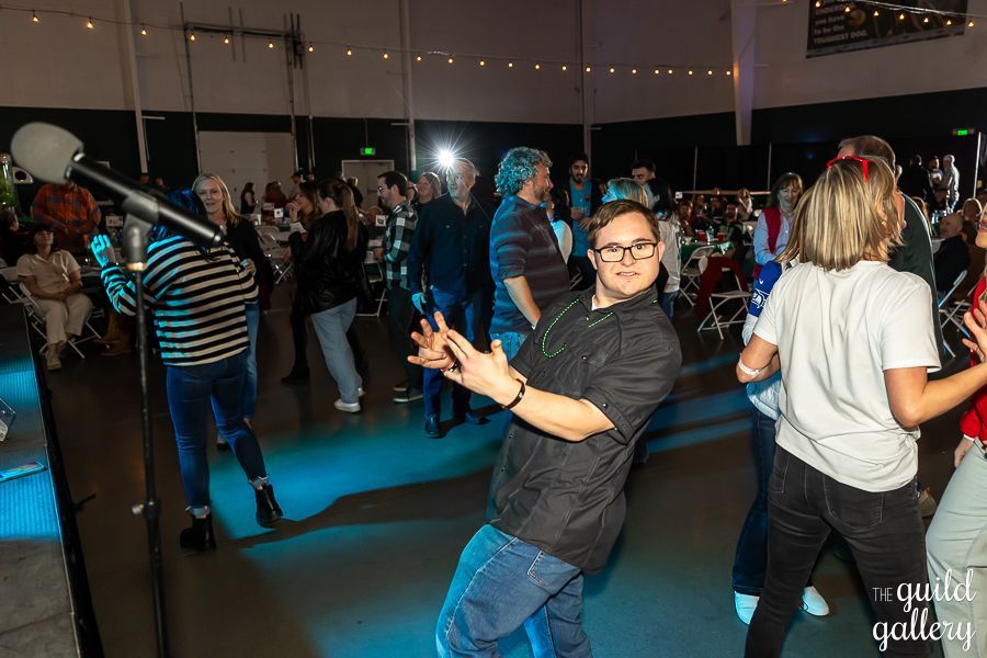 A group of people are dancing in a room at a party.