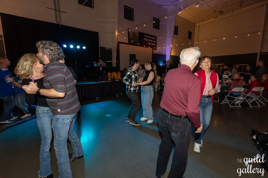 A group of people are dancing in a large room.