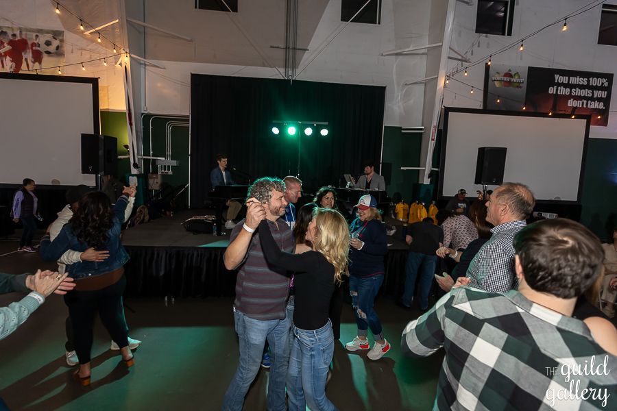 A group of people are dancing in a room at a party.