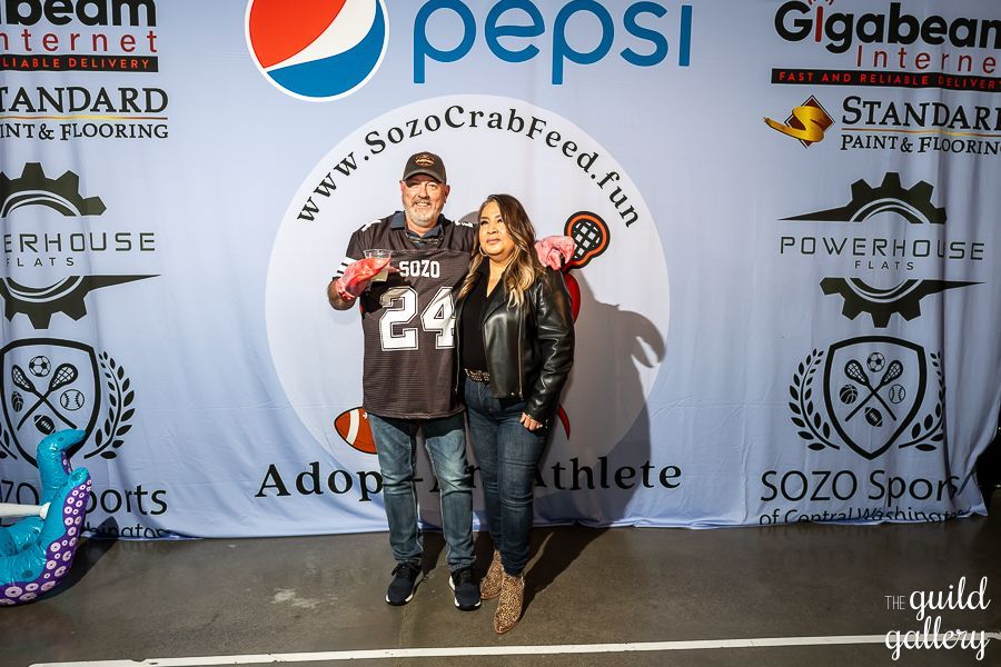 A man and woman standing in front of a pepsi banner