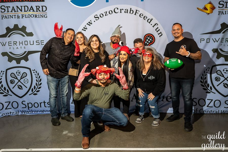 A group of people posing for a picture in front of a sign that says standard paint & flooring