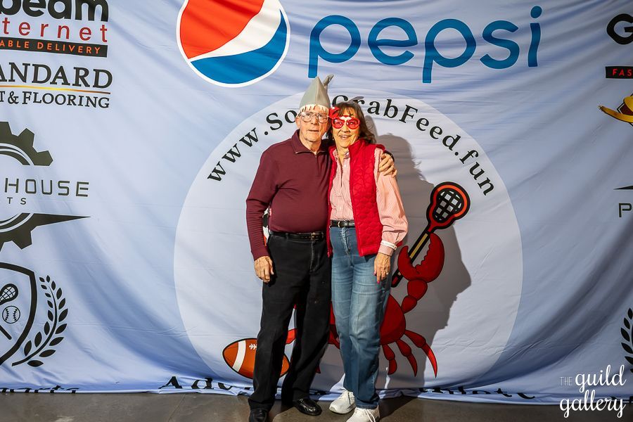 A man and woman pose in front of a pepsi banner