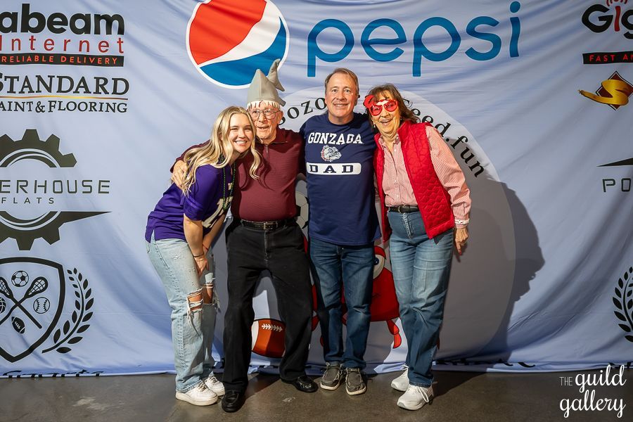A group of people posing for a picture in front of a pepsi banner