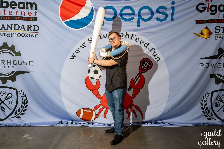 A man holding a baseball bat in front of a pepsi banner