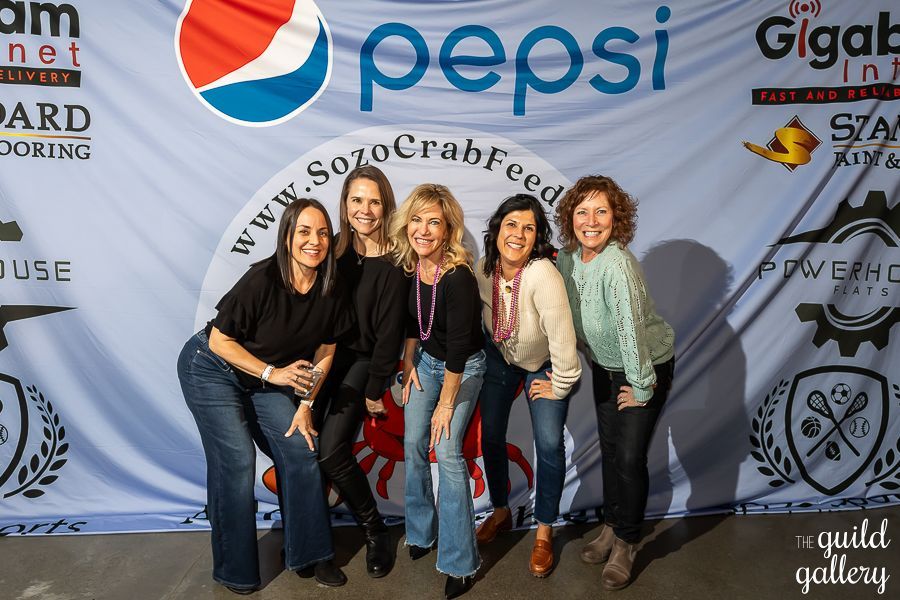 A group of women standing in front of a pepsi banner