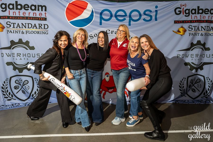 A group of women standing in front of a pepsi banner
