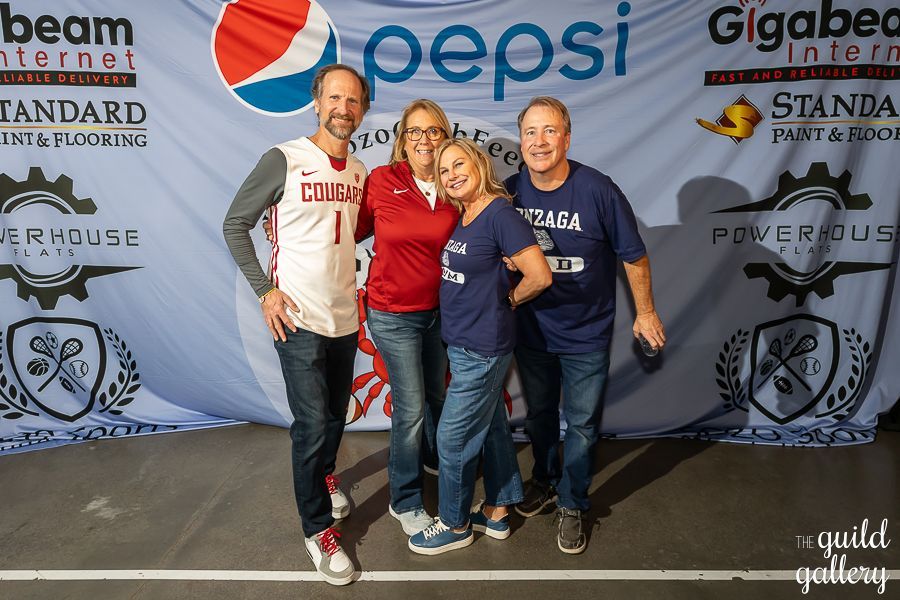 A group of people posing for a picture in front of a pepsi banner