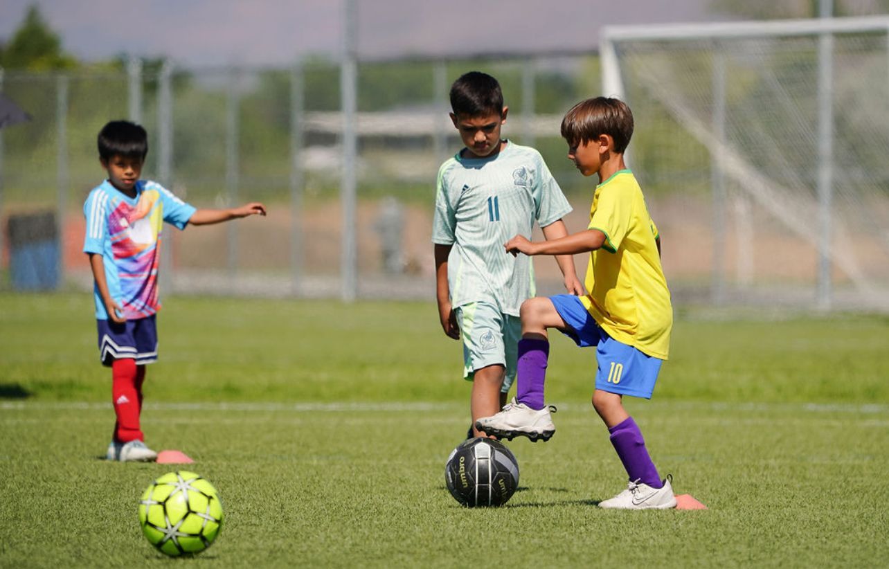 A group of young boys are playing soccer on a field.