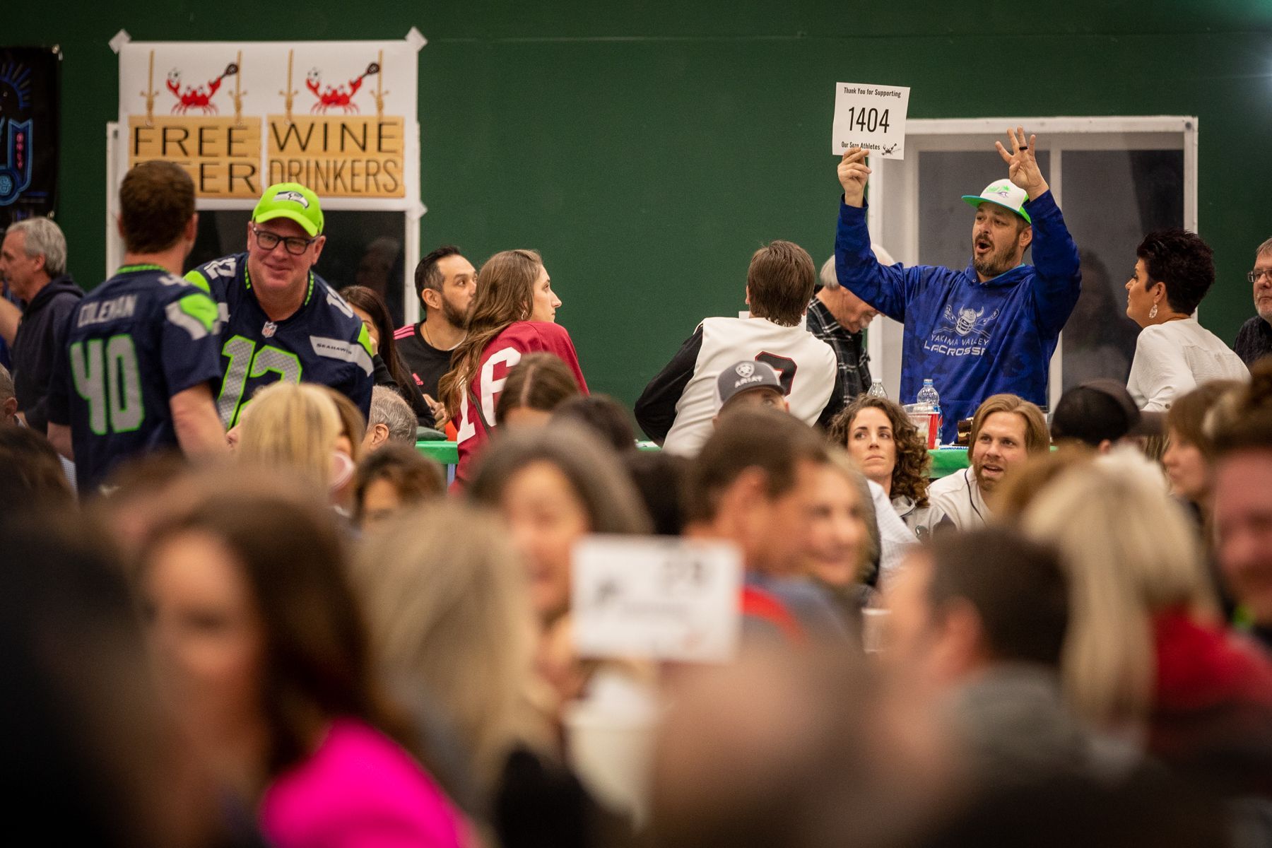 A man is holding a sign in front of a crowd of people.