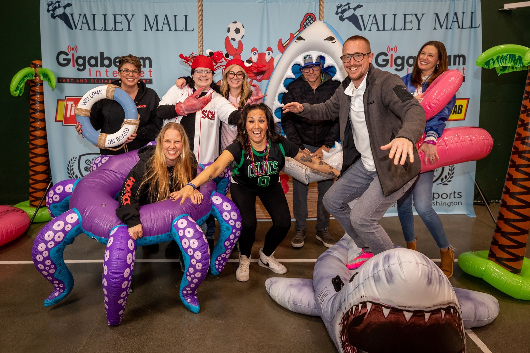 A group of people are posing for a picture with inflatable animals.