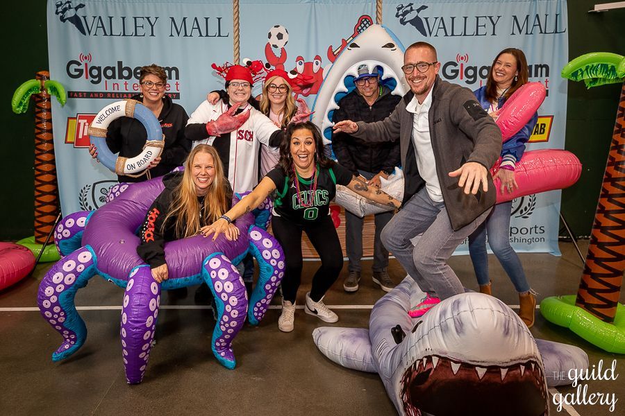 A group of people are posing for a picture with inflatable animals.