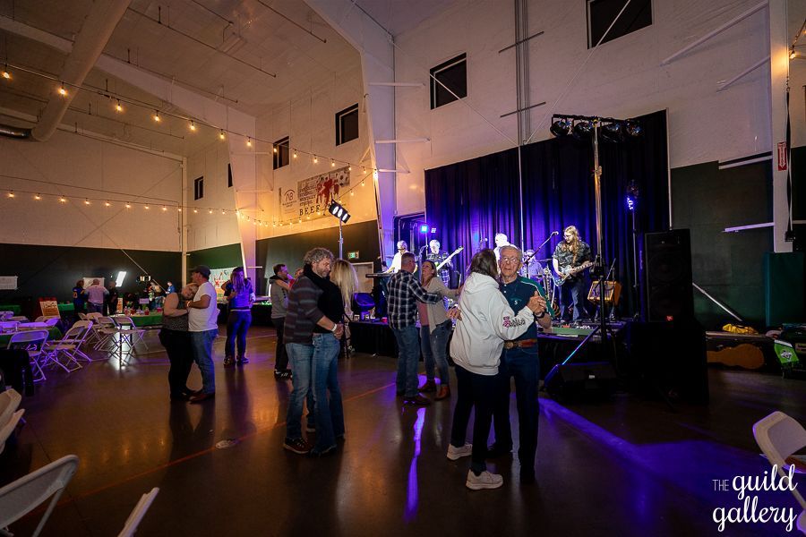 A group of people are dancing in a large room.
