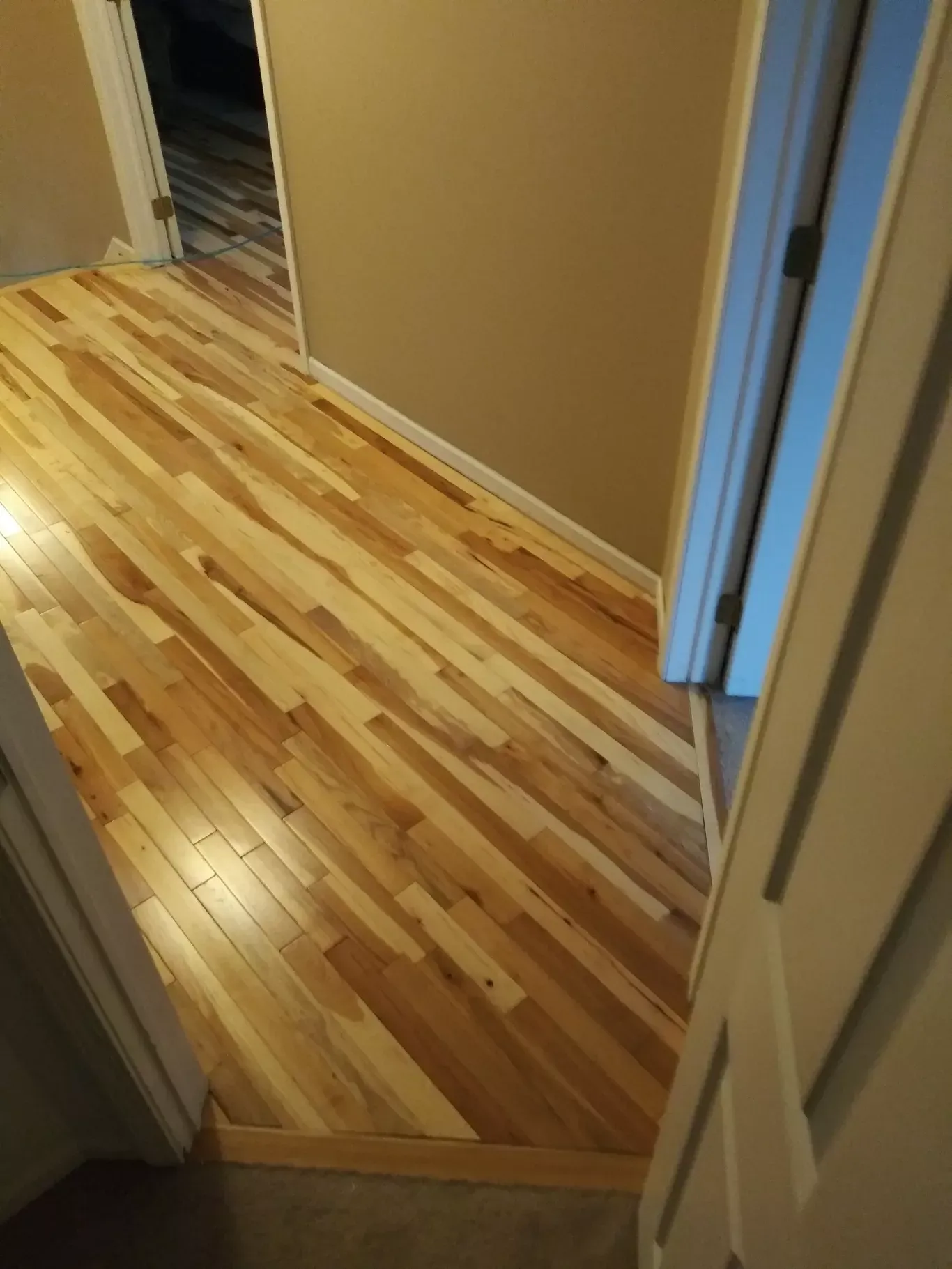 A hallway with hardwood floors and a doorway