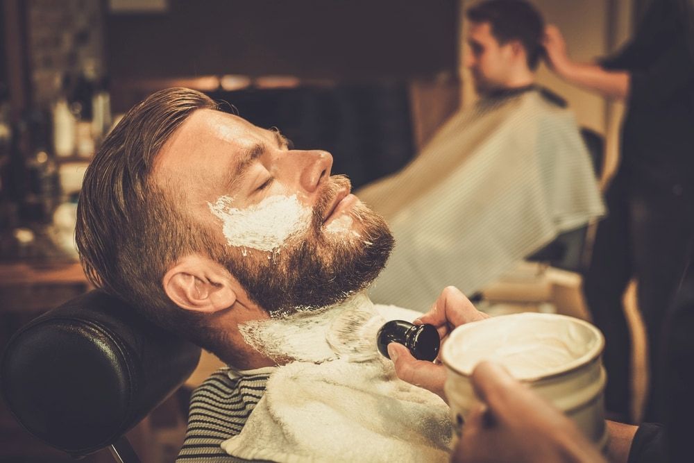 Man Getting a Shave at a Barber Shop; White Shaving Cream on His Face — Bermann Barbershop in Casey, ACT