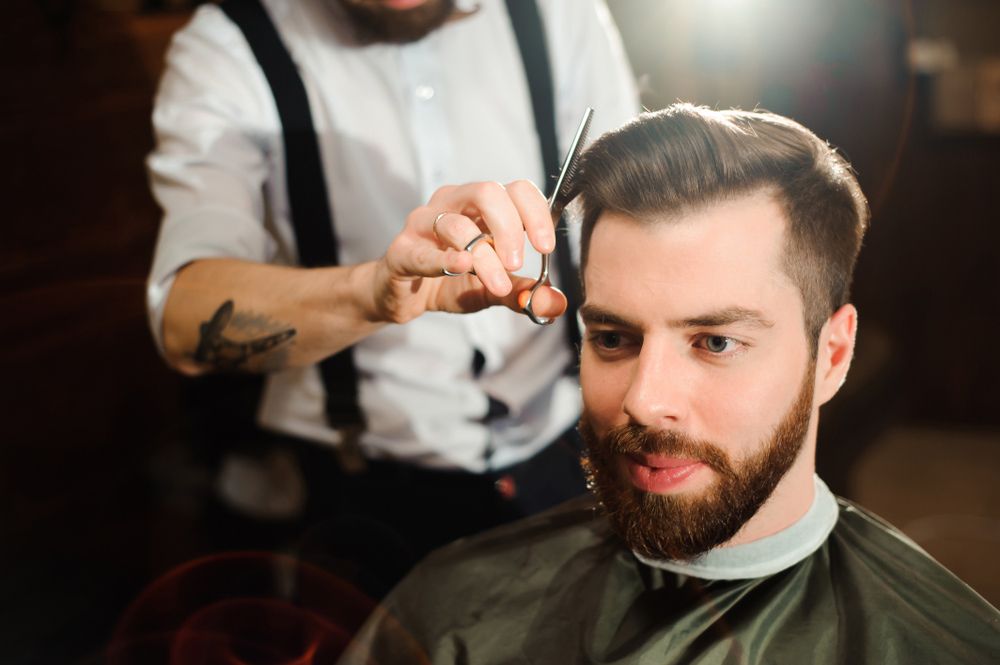 A Man Is Getting His Hair Cut — Bermann Barbershop In Casey, ACT