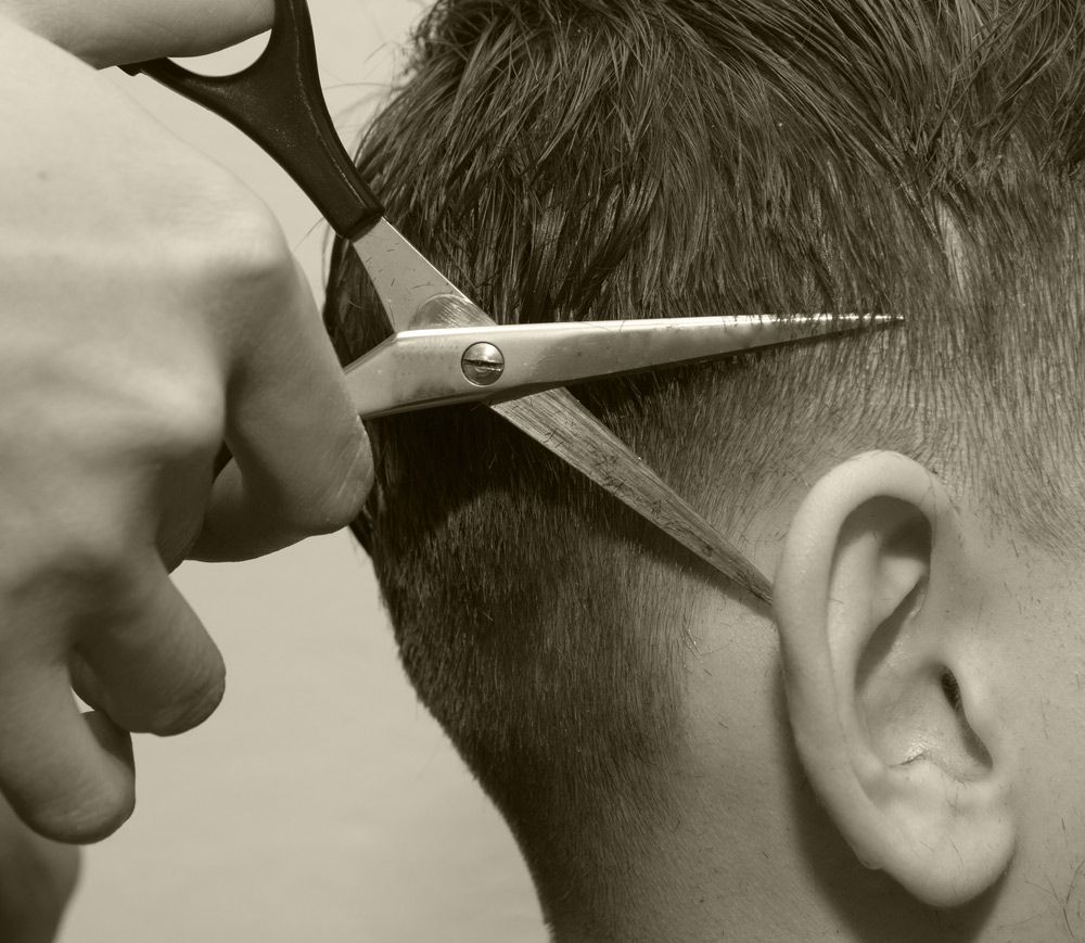 Getting His Hair Cut By A Barber With Scissors — Bermann Barbershop In Casey, ACT