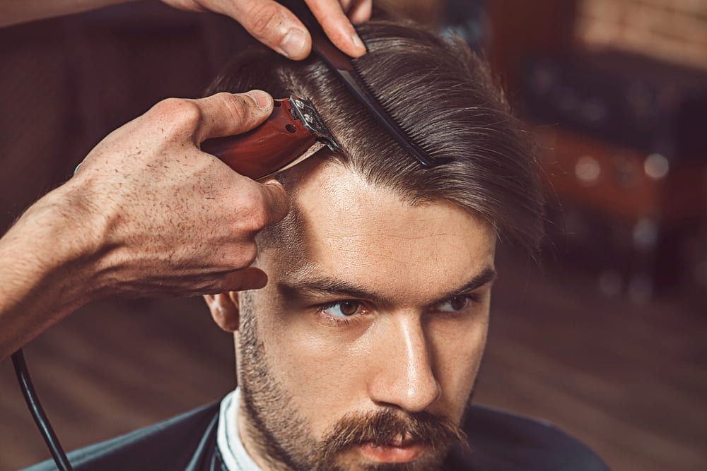 Man Getting a Haircut at a Barbershop With a Clipper and Comb — Bermann Barbershop in Casey, ACT