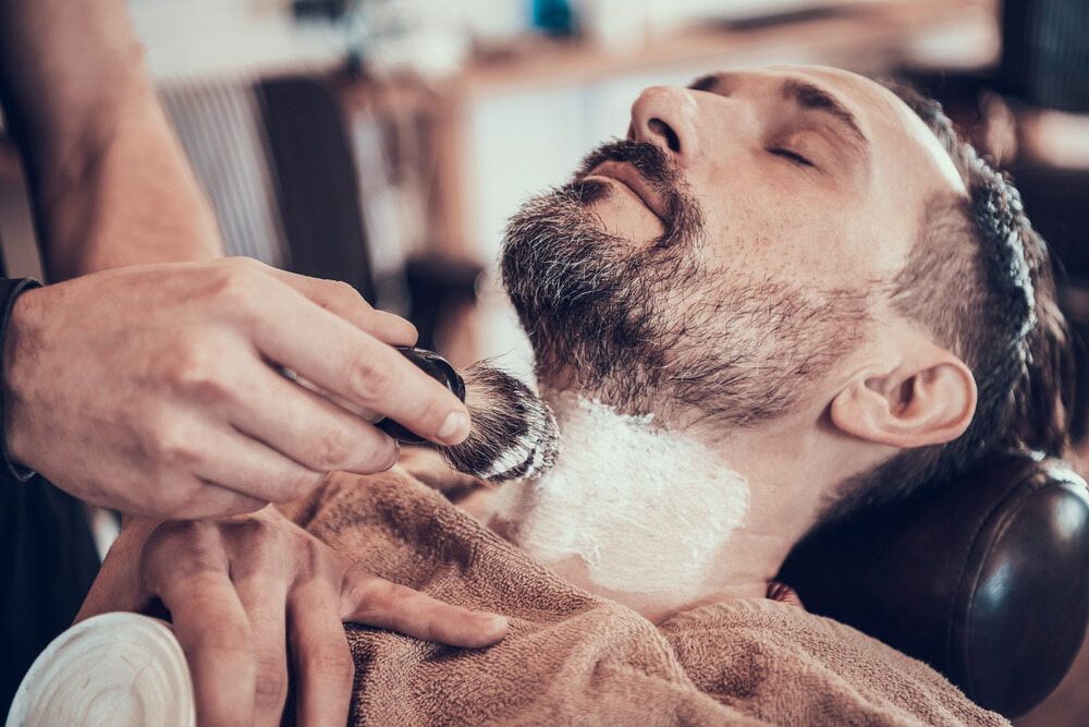Barber Applying Shaving Cream to a Man's Neck in a Barbershop — Bermann Barbershop in Casey, ACT