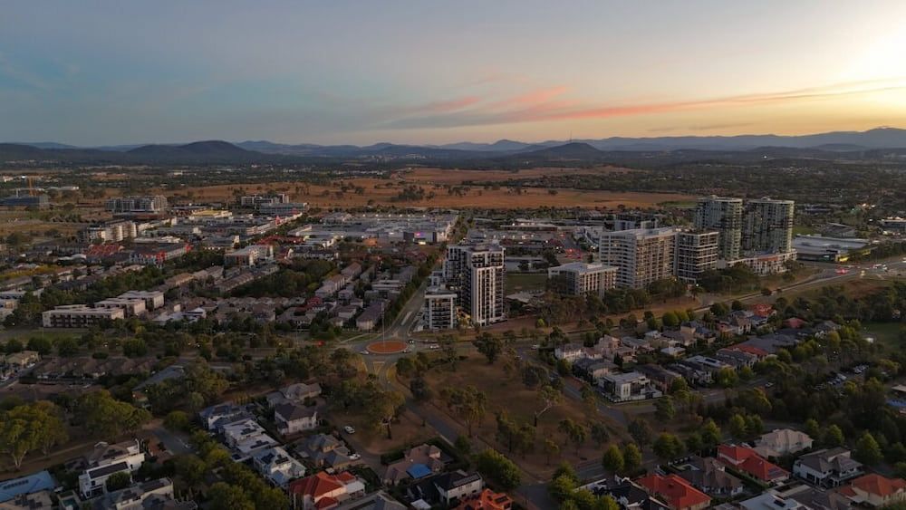 Aerial View of a City at Sunset, With Residential Buildings and Hills — Bermann Barbershop in Gungahlin, ACT