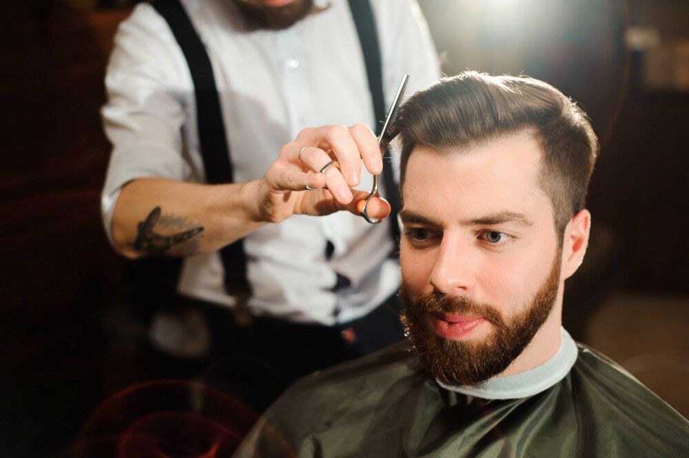 Man Getting a Haircut From a Barber With Scissors in a Barber Shop — Bermann Barbershop in Nicholls, ACT