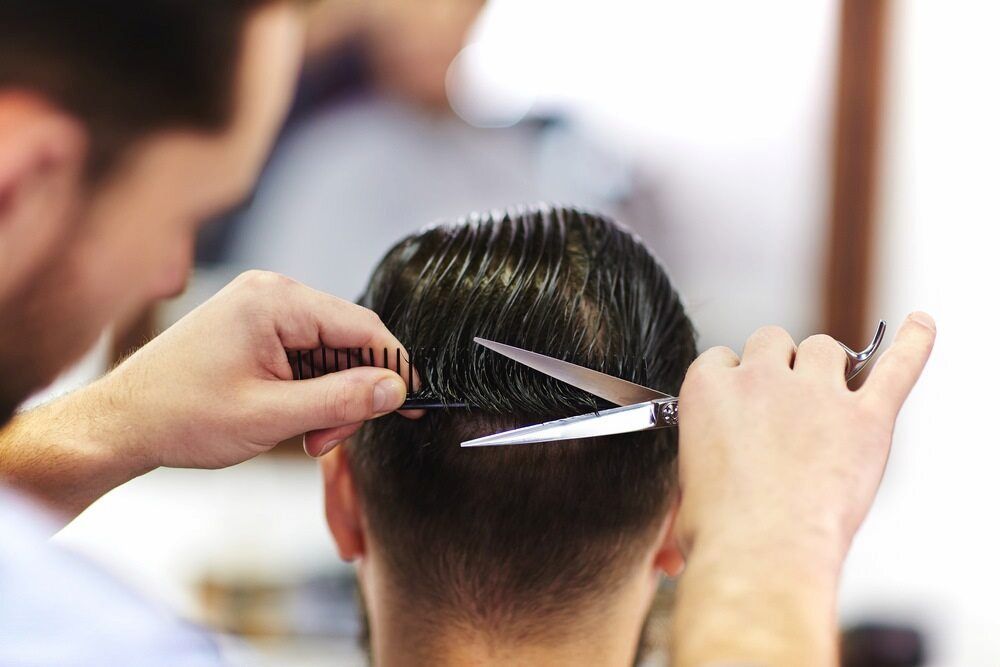 Hairdresser Cutting a Man's Hair With Scissors and a Comb — Bermann Barbershop in Casey, ACT