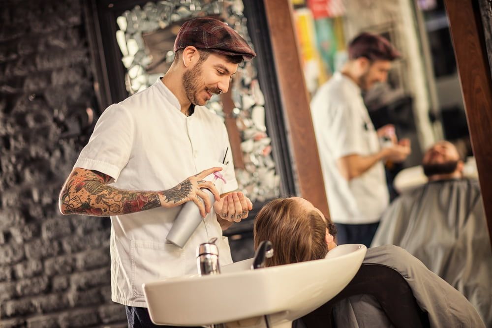 Barber Spraying Product on a Man's Wet Hair — Bermann Barbershop in Casey, ACT