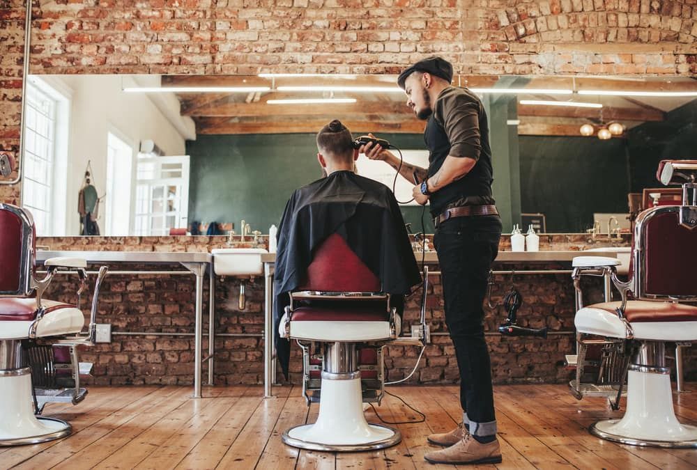 Barber Cutting a Man's Hair in a Brick-walled Barbershop — Bermann Barbershop in Ngunnawal, ACT