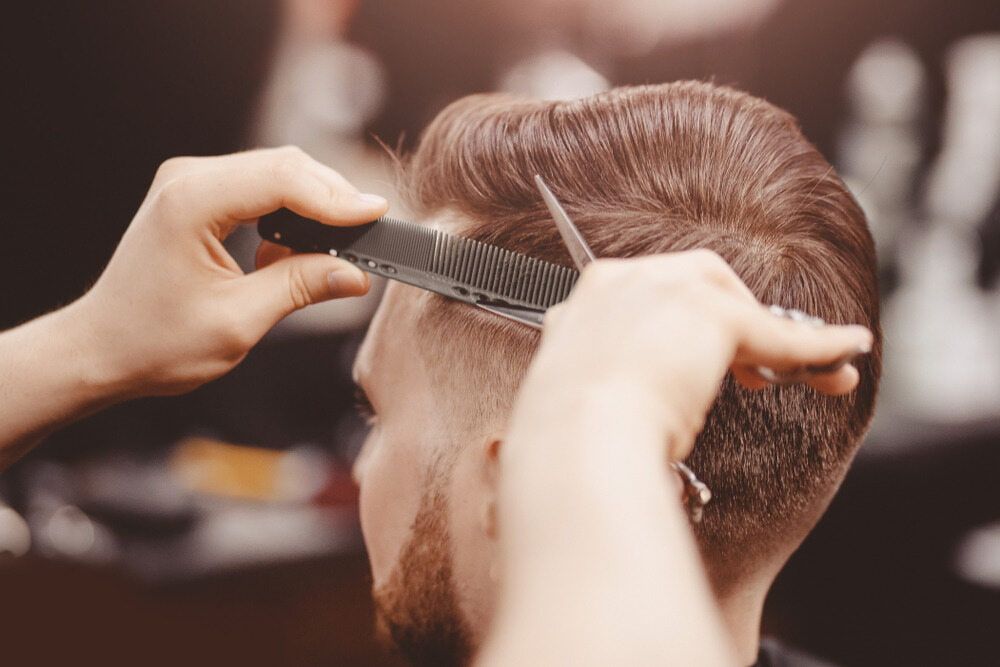 Barber Cutting a Man's Hair With Comb and Scissors in a Shop — Bermann Barbershop in Casey, ACT