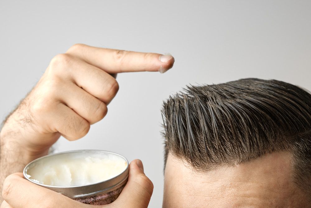 Man Applying Hair Wax to Styled Hair With a Fingertip — Bermann Barbershop in Casey, ACT