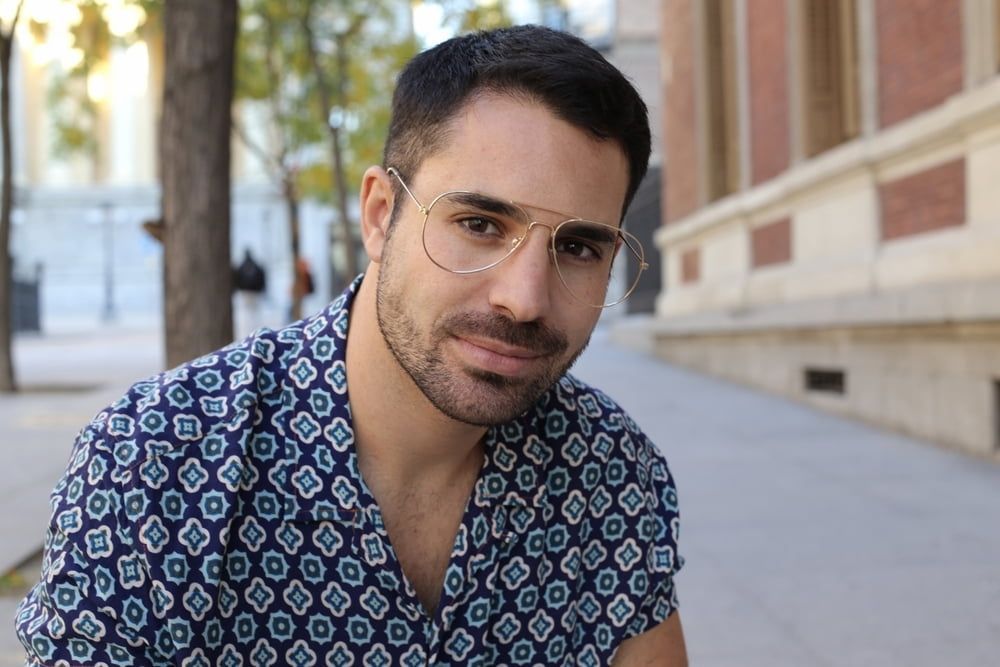 Man With Glasses in Patterned Shirt, Smiling Outdoors — Bermann Barbershop in Gungahlin, ACT