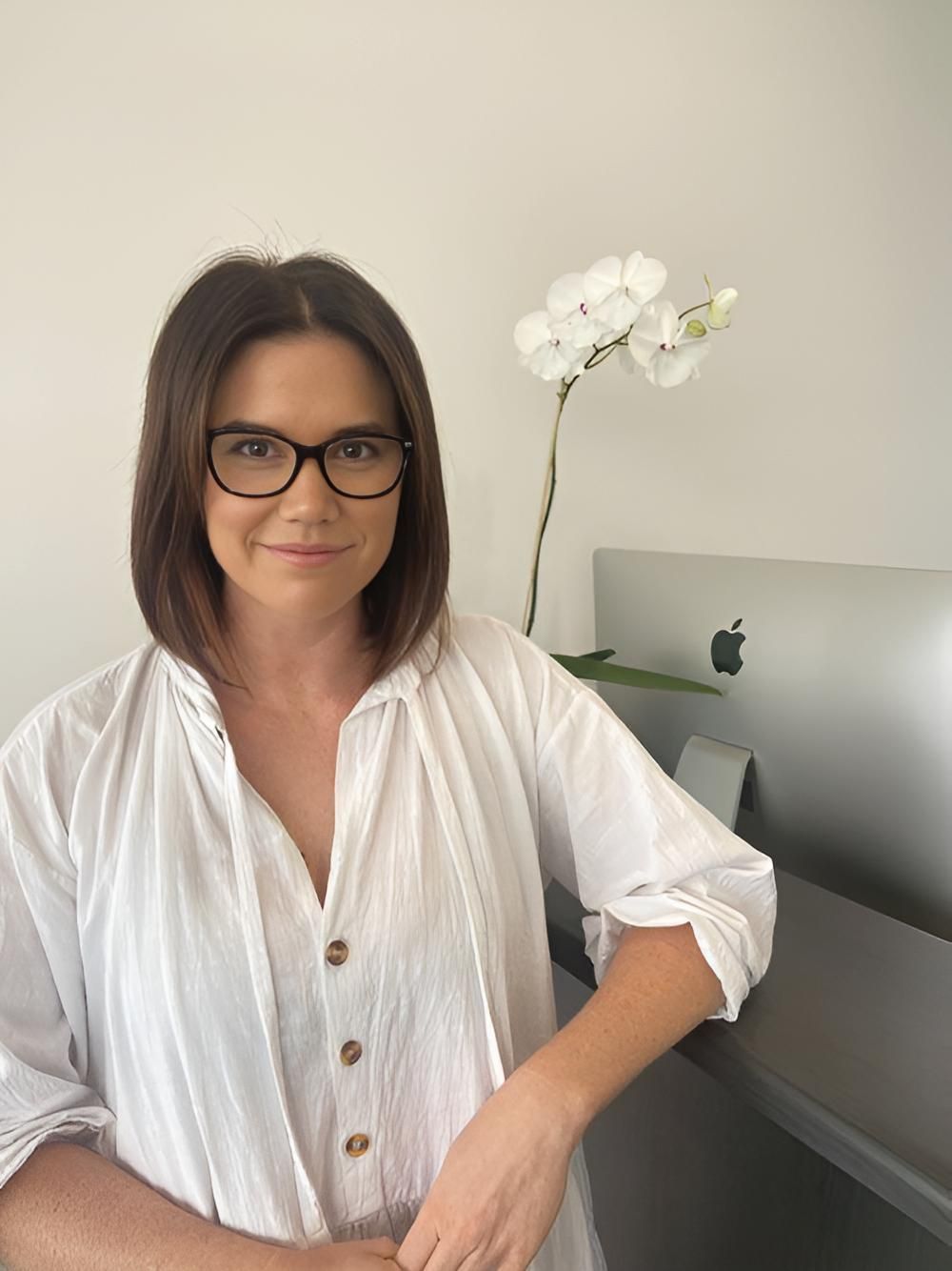 A Woman Wearing Glasses And A White Shirt — Grays Chiropractic Centre In Rural View, QLD