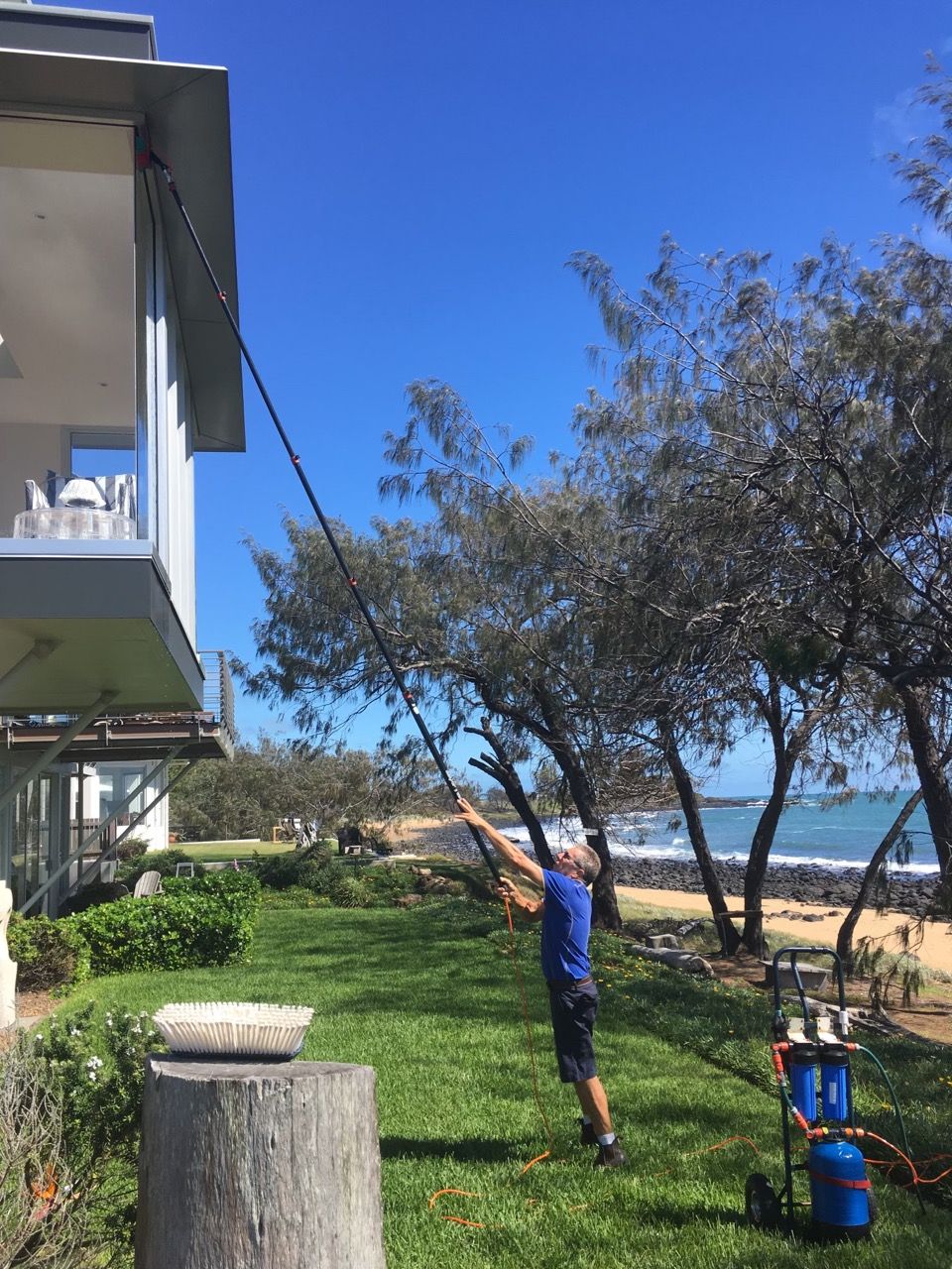Worker Cleaning Window — Cleaning Company in Bundaberg