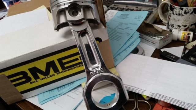 A piston is sitting on a table next to a box that says bme